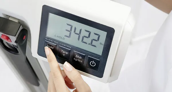Woman hand setting up the Seca 777 Scale display