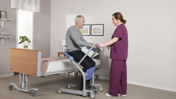 Elder man being helped using the Sara Stedy Patient Transfer Aid by ArjoHuntleigh