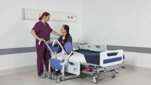 Elder woman sitting on hospital bed with the Sara Stedy Patient Transfer Aid by ArjoHuntleigh