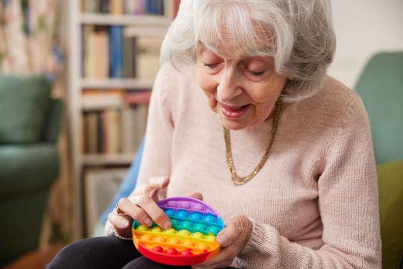 elderly-woman-using-pop-toy