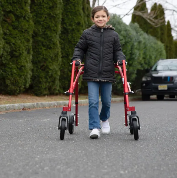 Girl walking with the Klip Gait Trainer Posterior Pediatric Walker outdoors