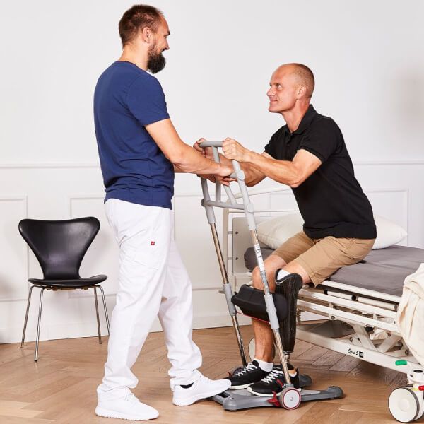 Injured man using the Molift Raiser Pro Sit-to-Stand Patient Lift to stand up from bed
