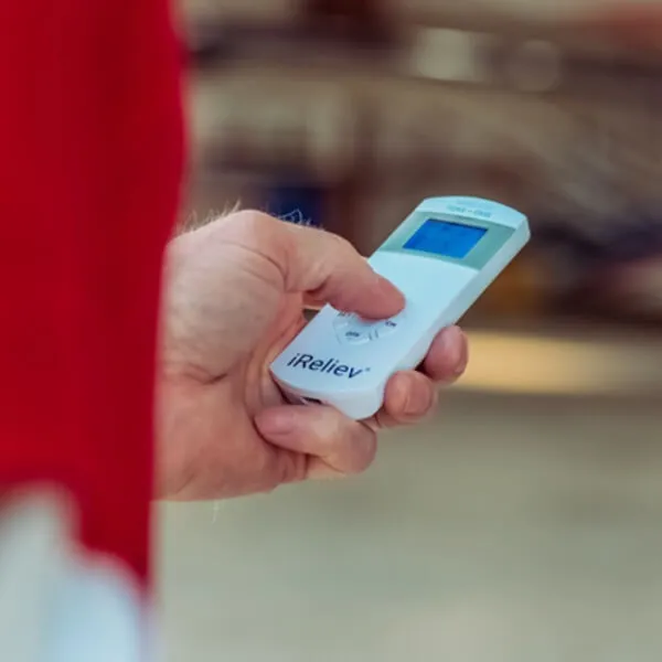 Man holding portable and wireless iReliev remote with backlit display