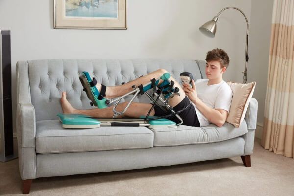 Man resting at home with a Continuous Passive Motion Machine