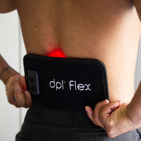 Man using red light therapy device to treat is lower back pain