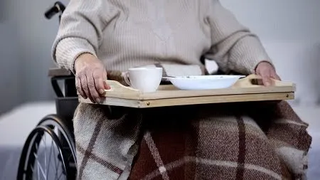 person-in-wheelchair-holding-tray