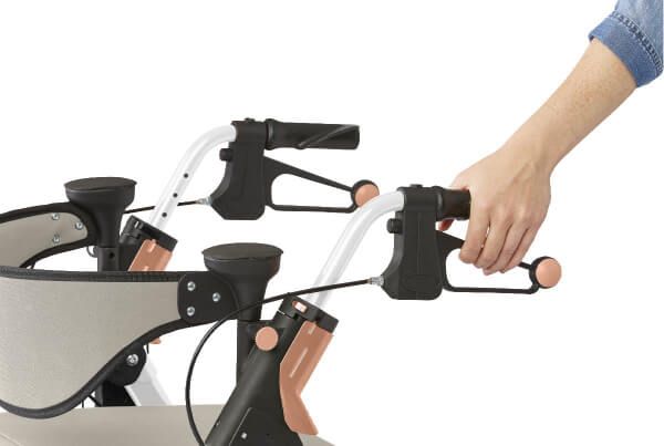 User holding the ergonomic Empower Portable Folding Rollator by Medline brakes