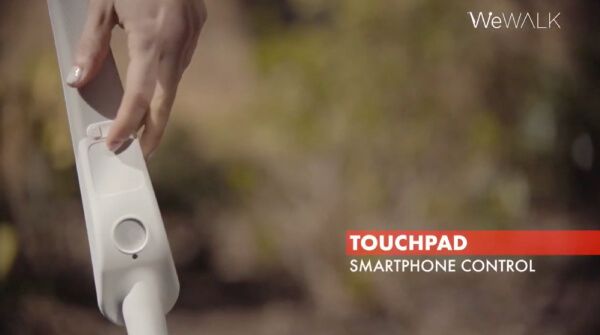 Woman controlling smartphone with We Walk Touchpad