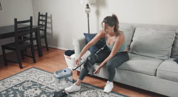 Woman wrapping a cryotherapy pad on her knee to recover at home